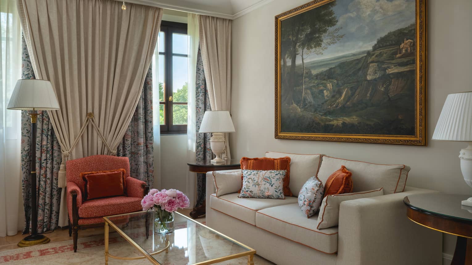 Hotel room featuring a sofa, arm chair, glass coffee table and large painting on the wall