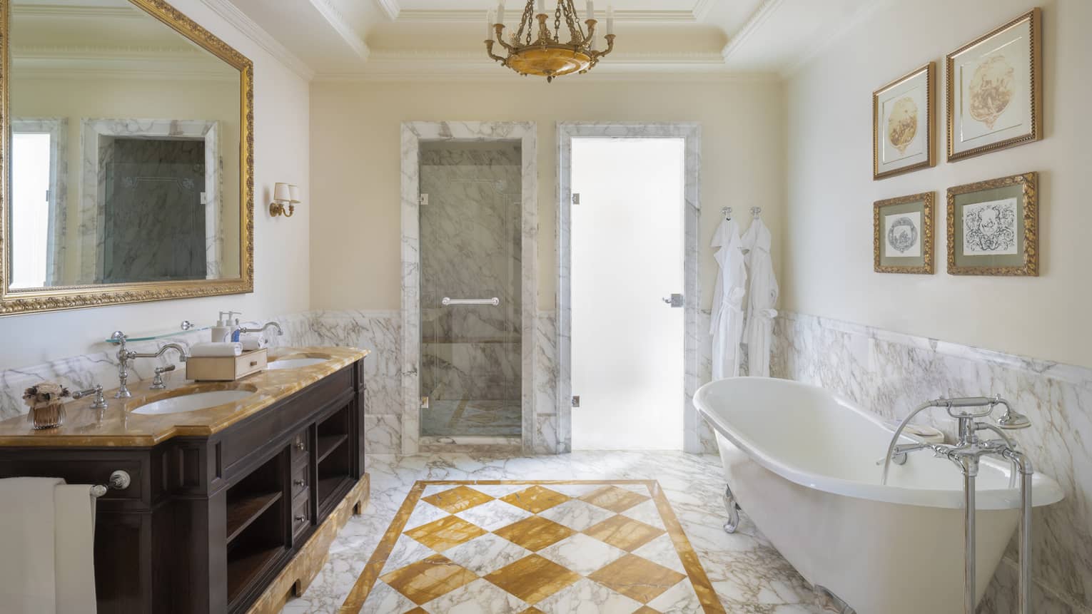 Elegant bathroom of hotel room, featuring marble floors, chandelier and claw-foot tub