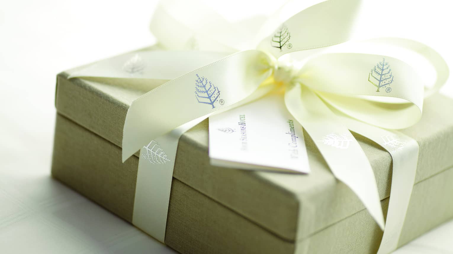 Gift box wrapped up with Four Seasons branded ribbon with a card