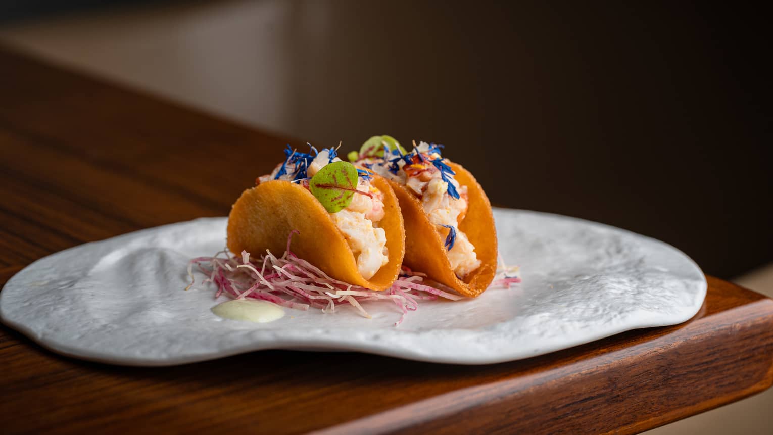 Lobster Tacos with Micro Greens garnish on white plate