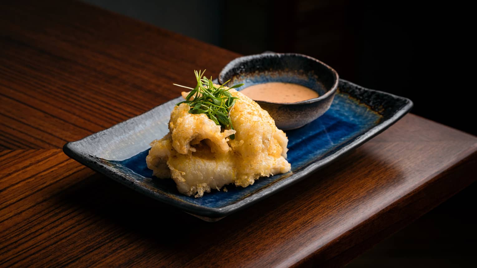 Perch Tempura on rectangular blue ceramic dish with orange-coloured dipping sauce in bowl
