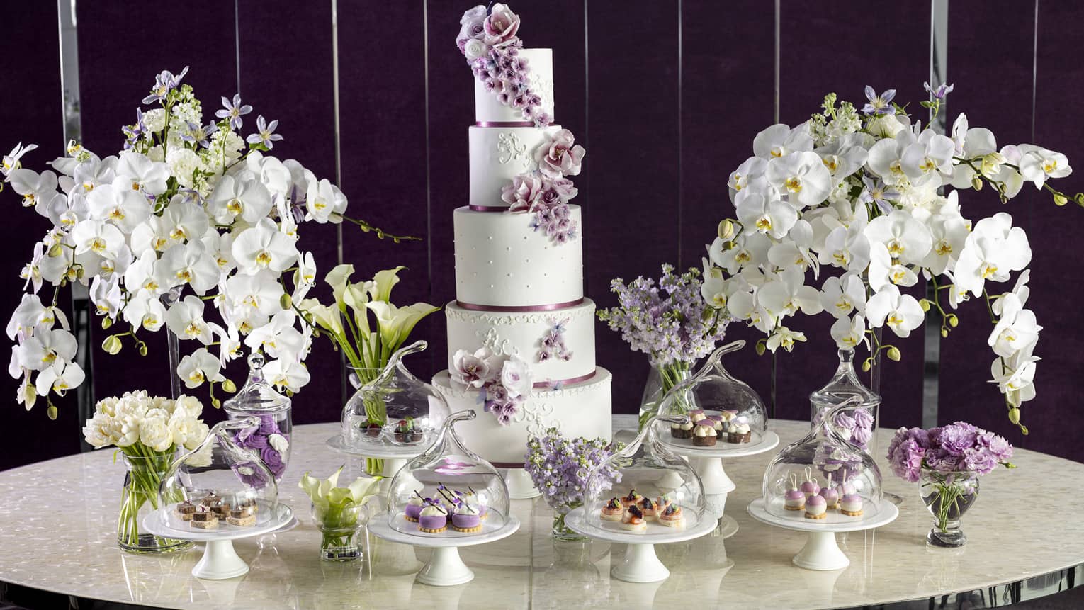 Wedding cake and cupcake display with white orchids