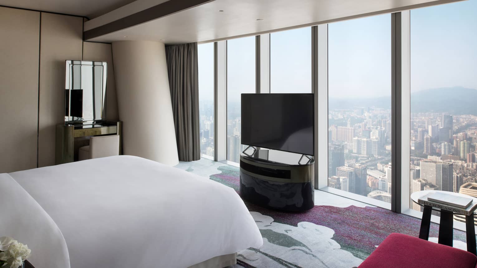 Deluxe King Suite City View Room with red accents and floor-to-ceiling windows