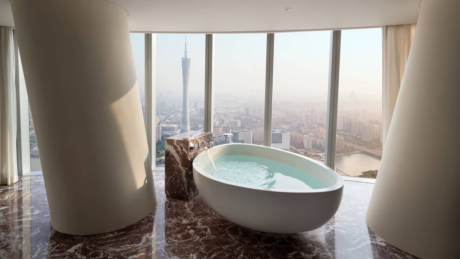 Premier King Canton Tower View Room large soaking tub in front of floor-to-ceiling windows with natural light