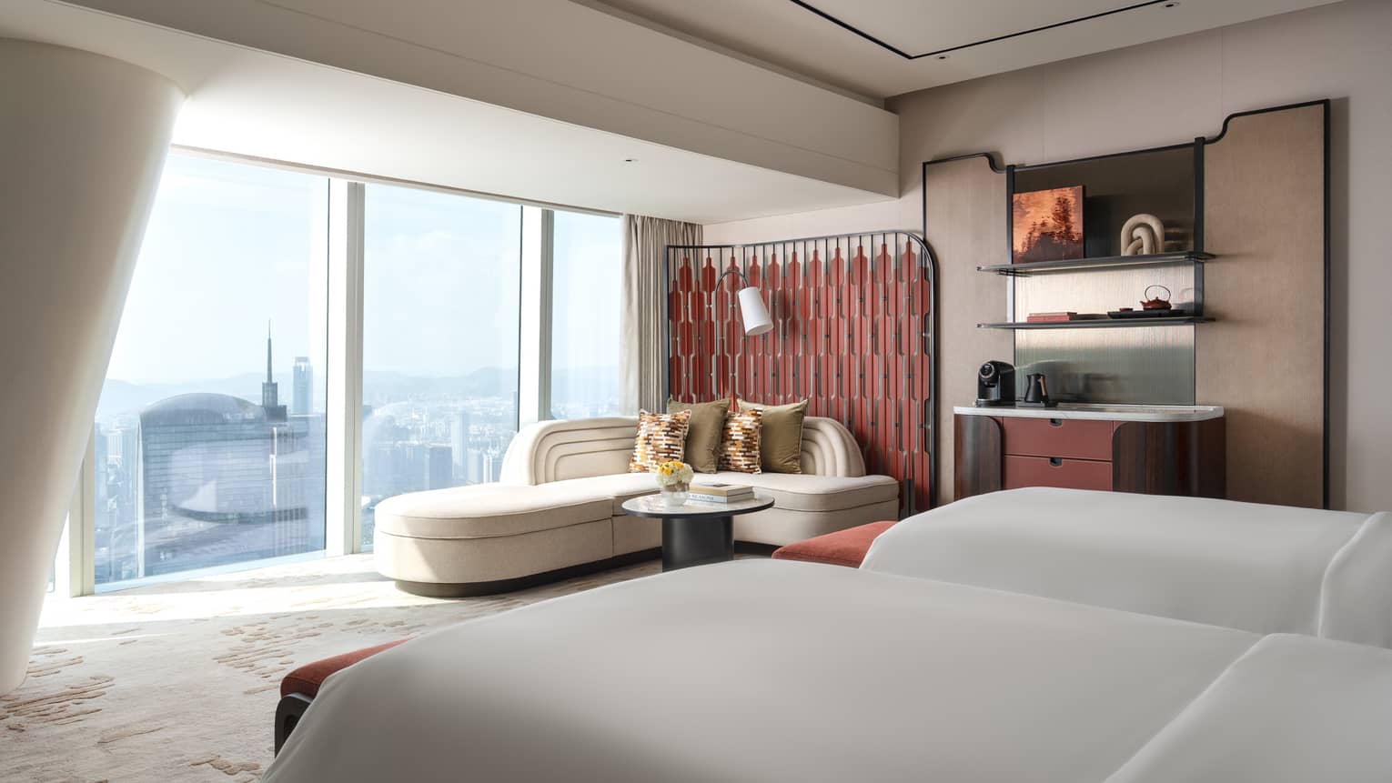 Hotel room with two beds and a chaise next to the wall of windows