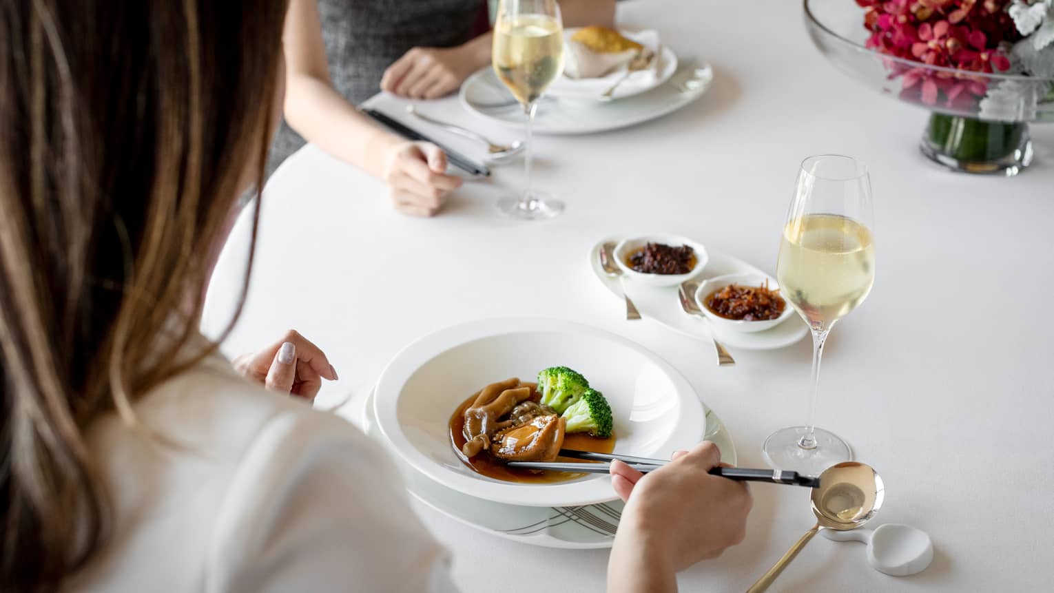 Two people eat at fine dining table at Four Seasons Hotel Hong Kong restaurant