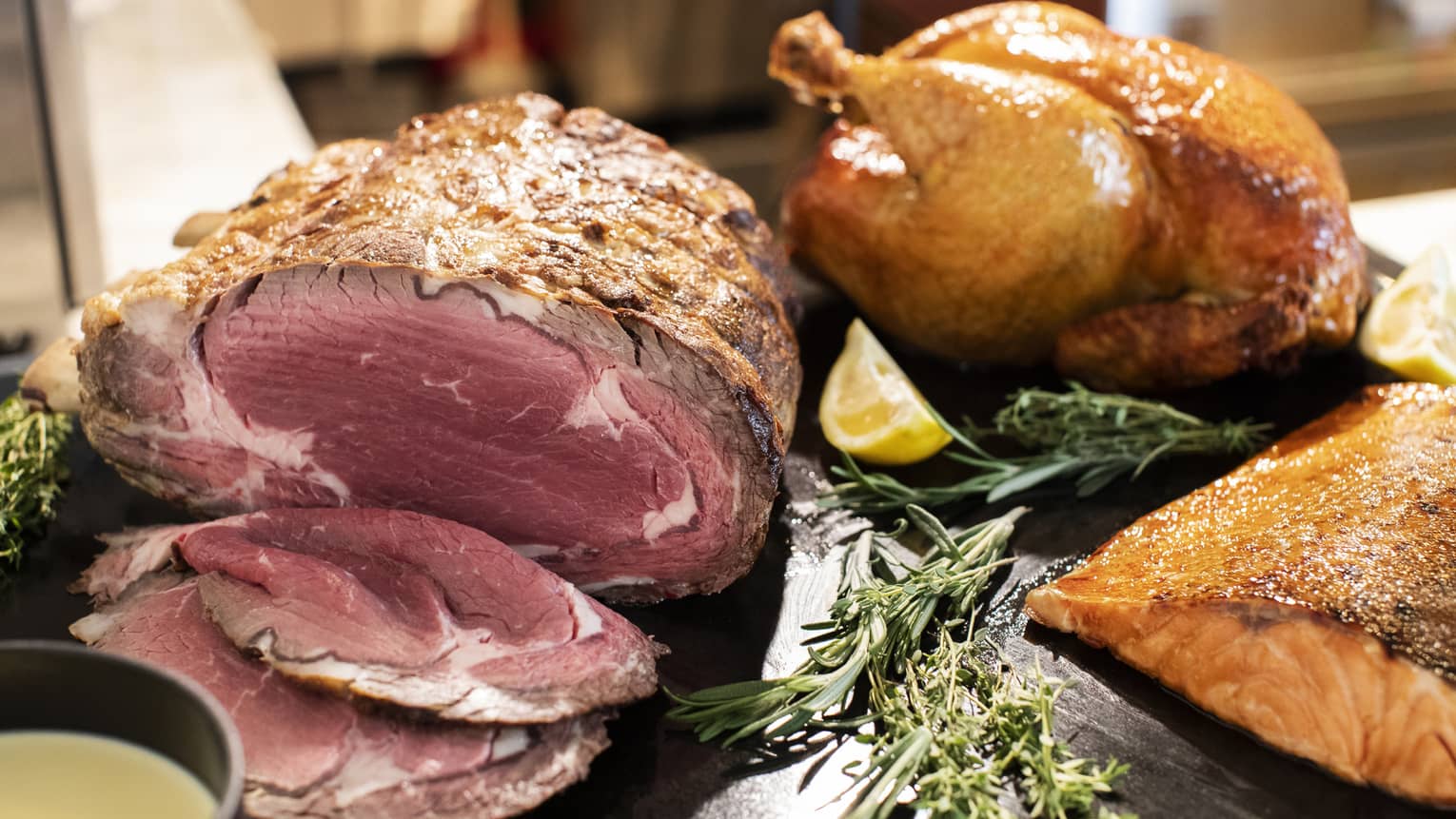 Holiday prime rib, whole turkey and side of salmon on black display board