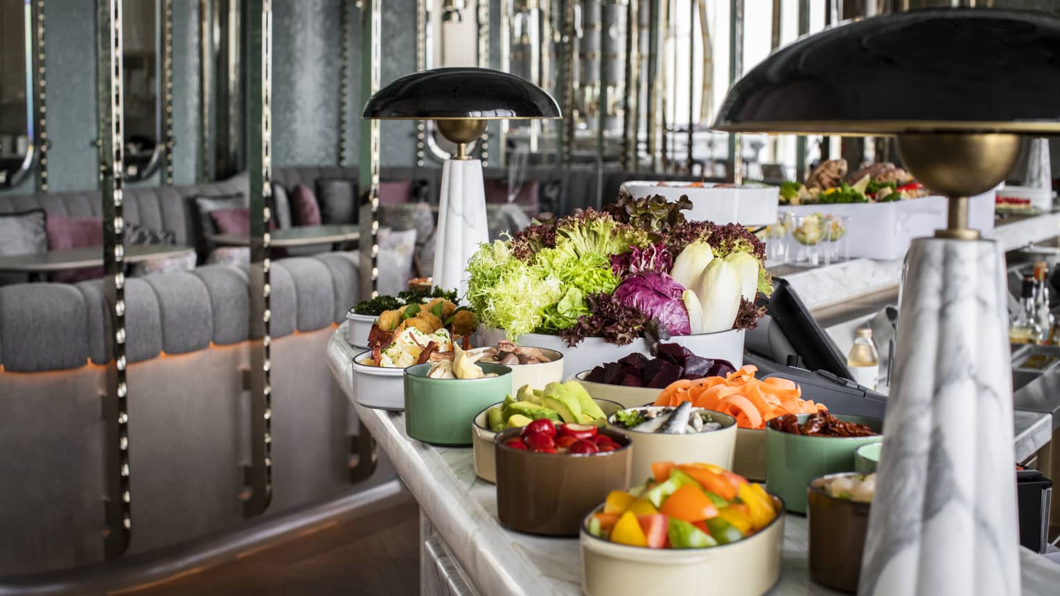 A small buffet of food near a mirrored wall.