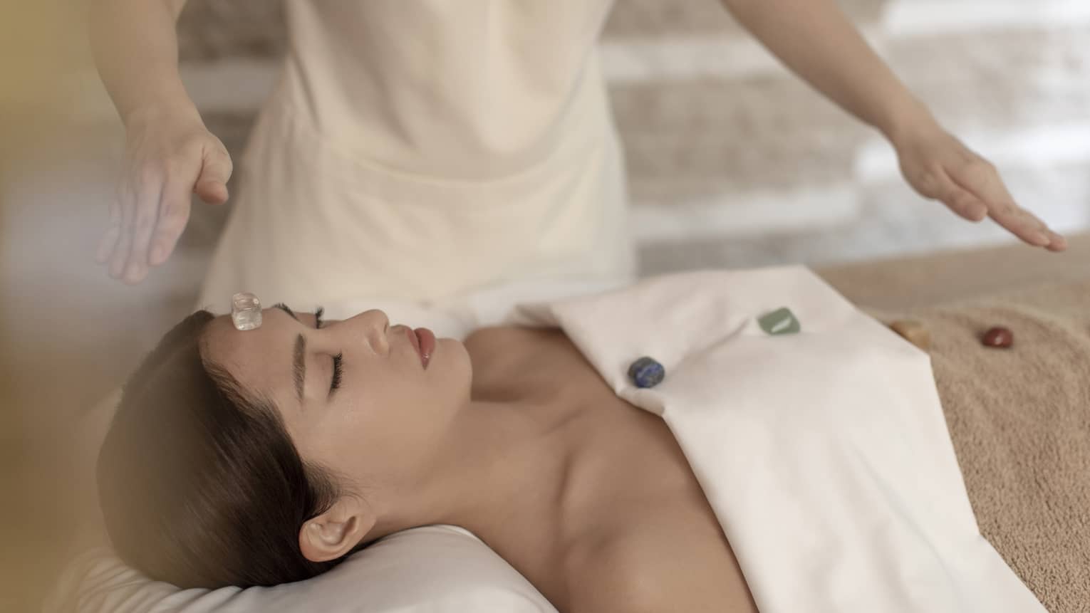 Woman gets a massage with gem stones