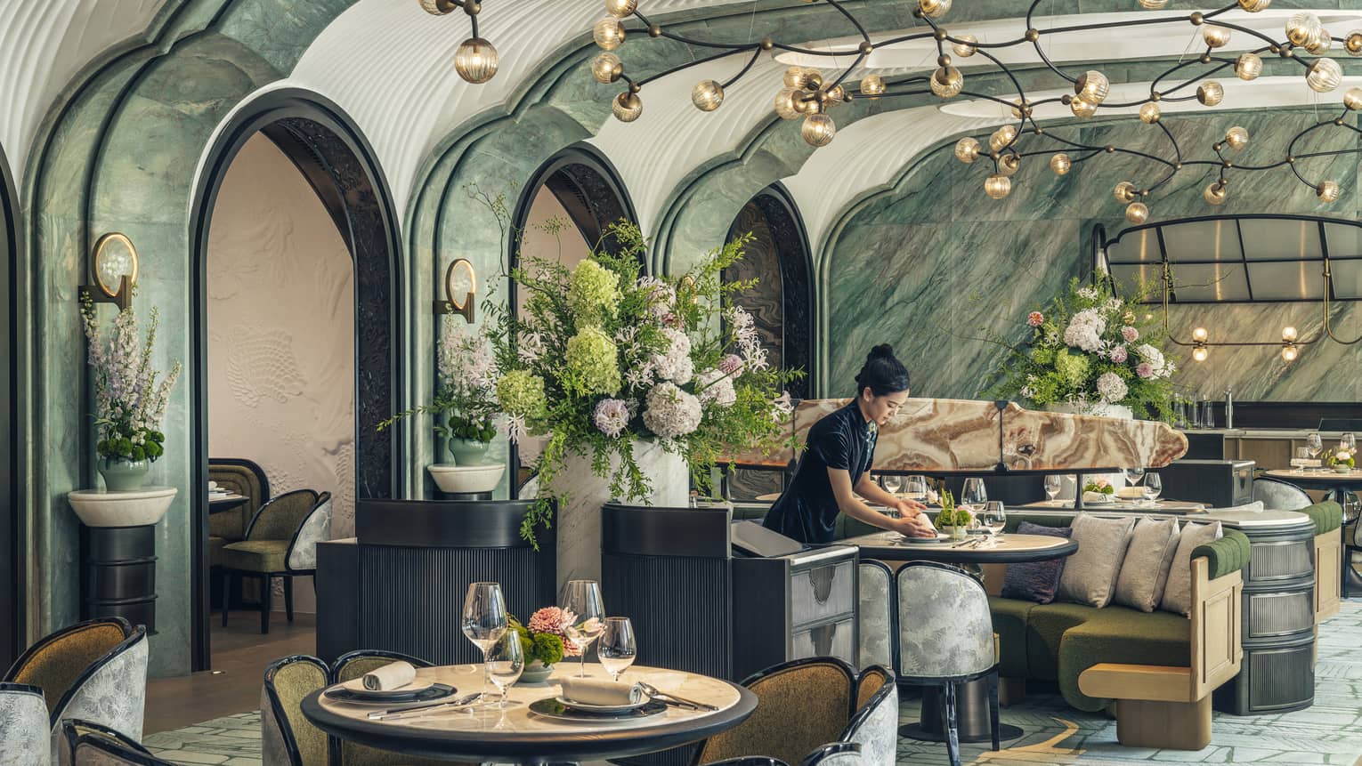 Woman sets table at contemporary Chinese restaurant Song at Four Seasons Hotel Hangzhou at Hangzhou Centre