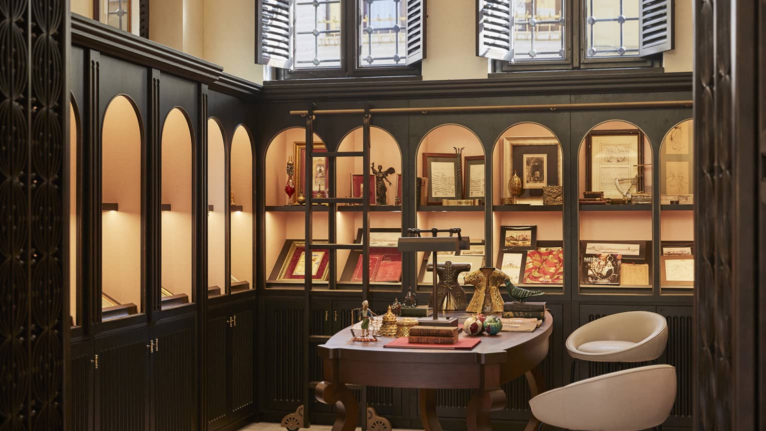 A store with items and books on shelves and a small table with chairs.