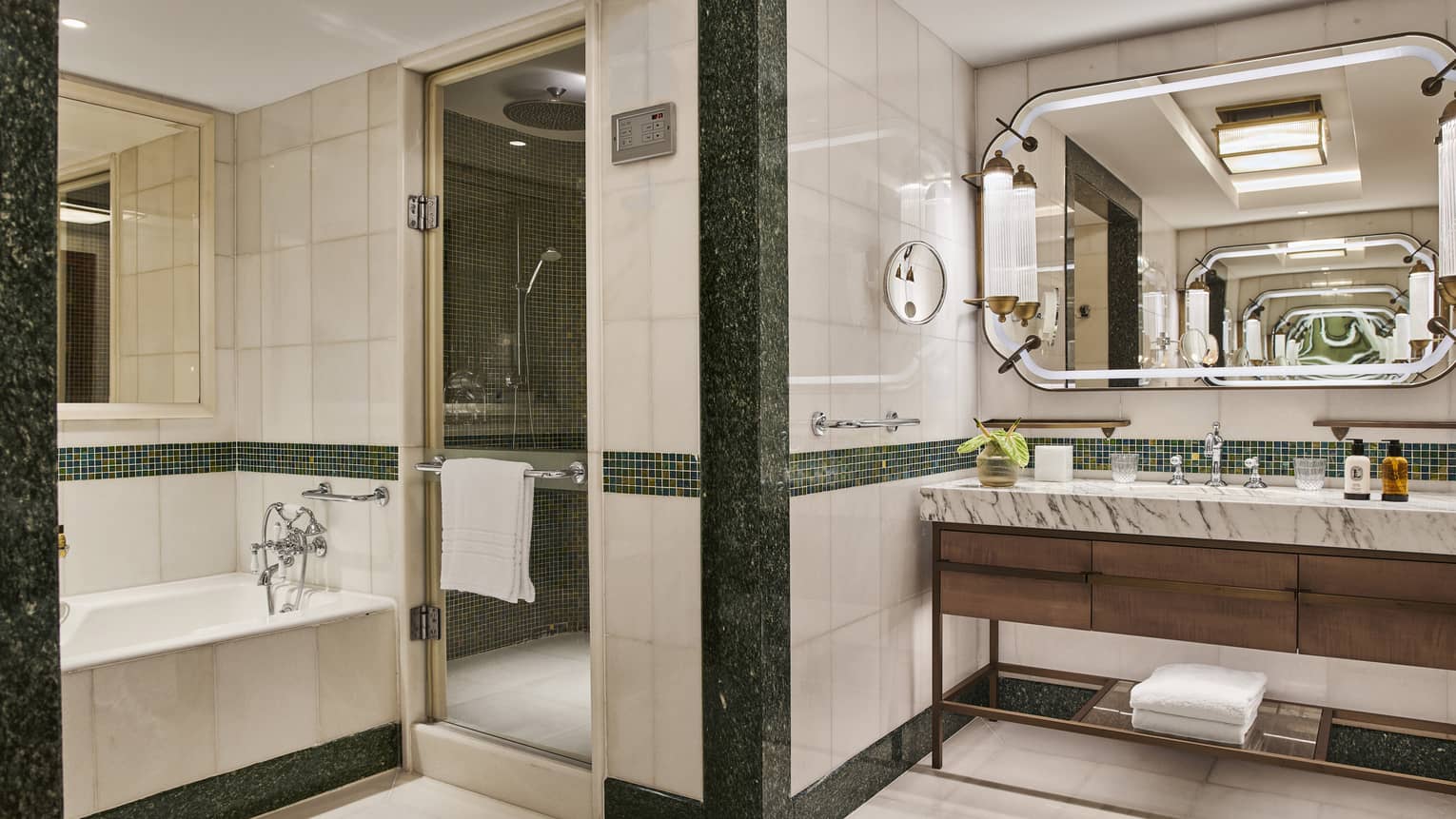 Modern full marble bathroom with soaking tub, double vanity and large mirror with sconces