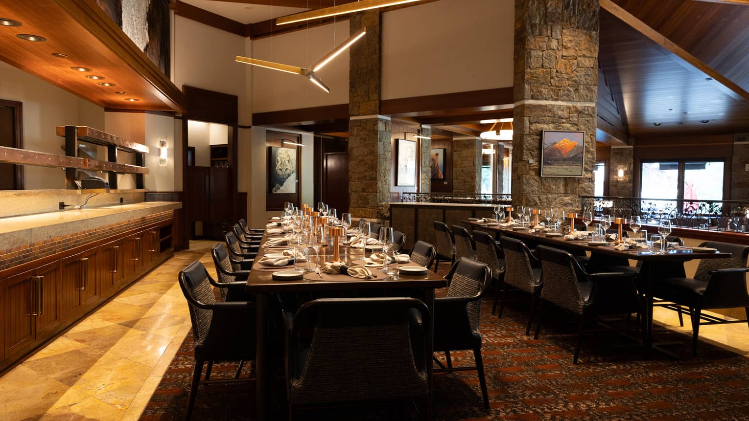 A dining room with long rectangular tables and brick columns throughout the room