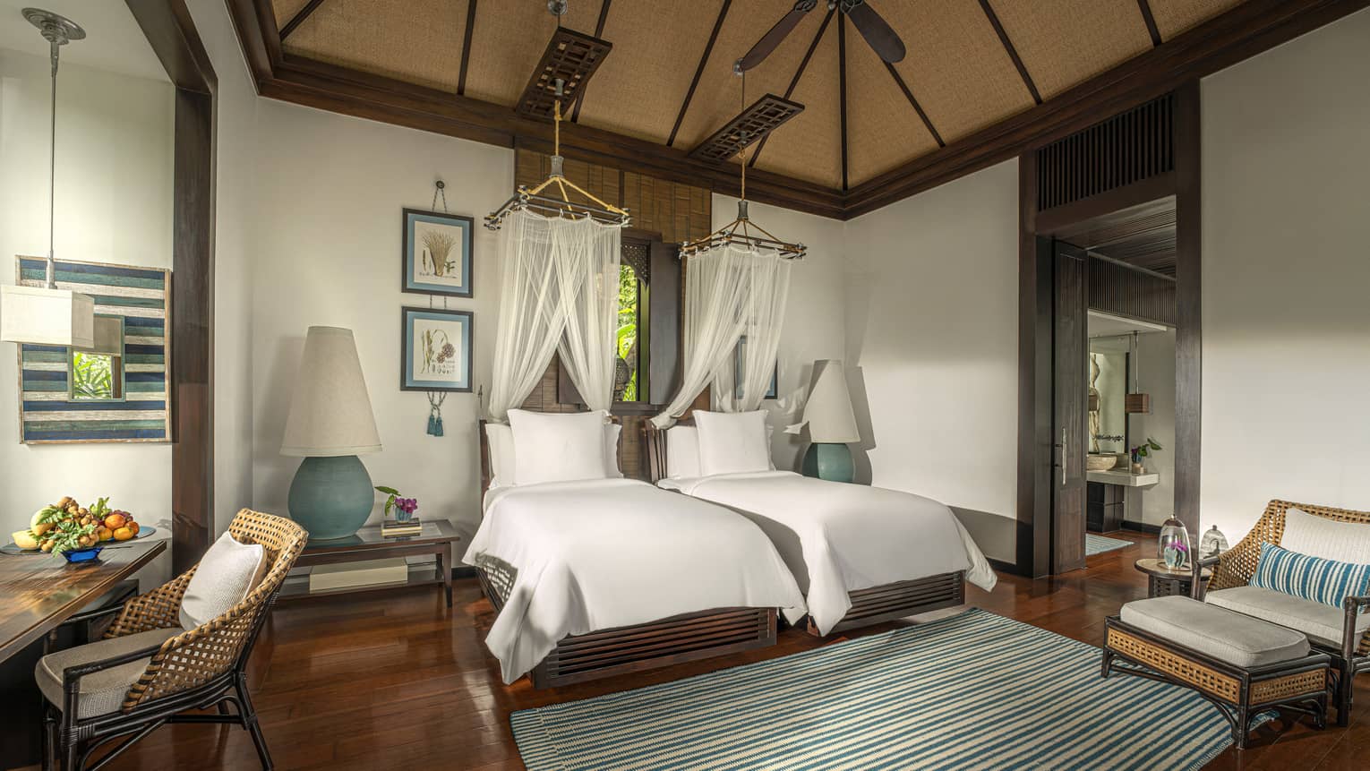 Bedroom with two twin beds, each with a net canopy