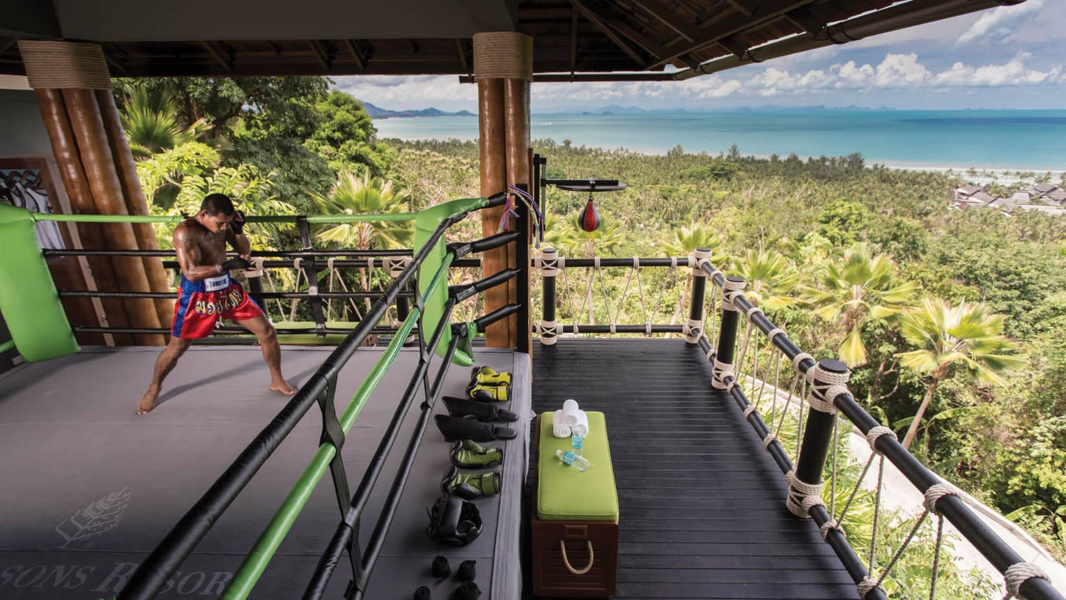 Boxer practices in Muay Thai boxing ring high up in mountain