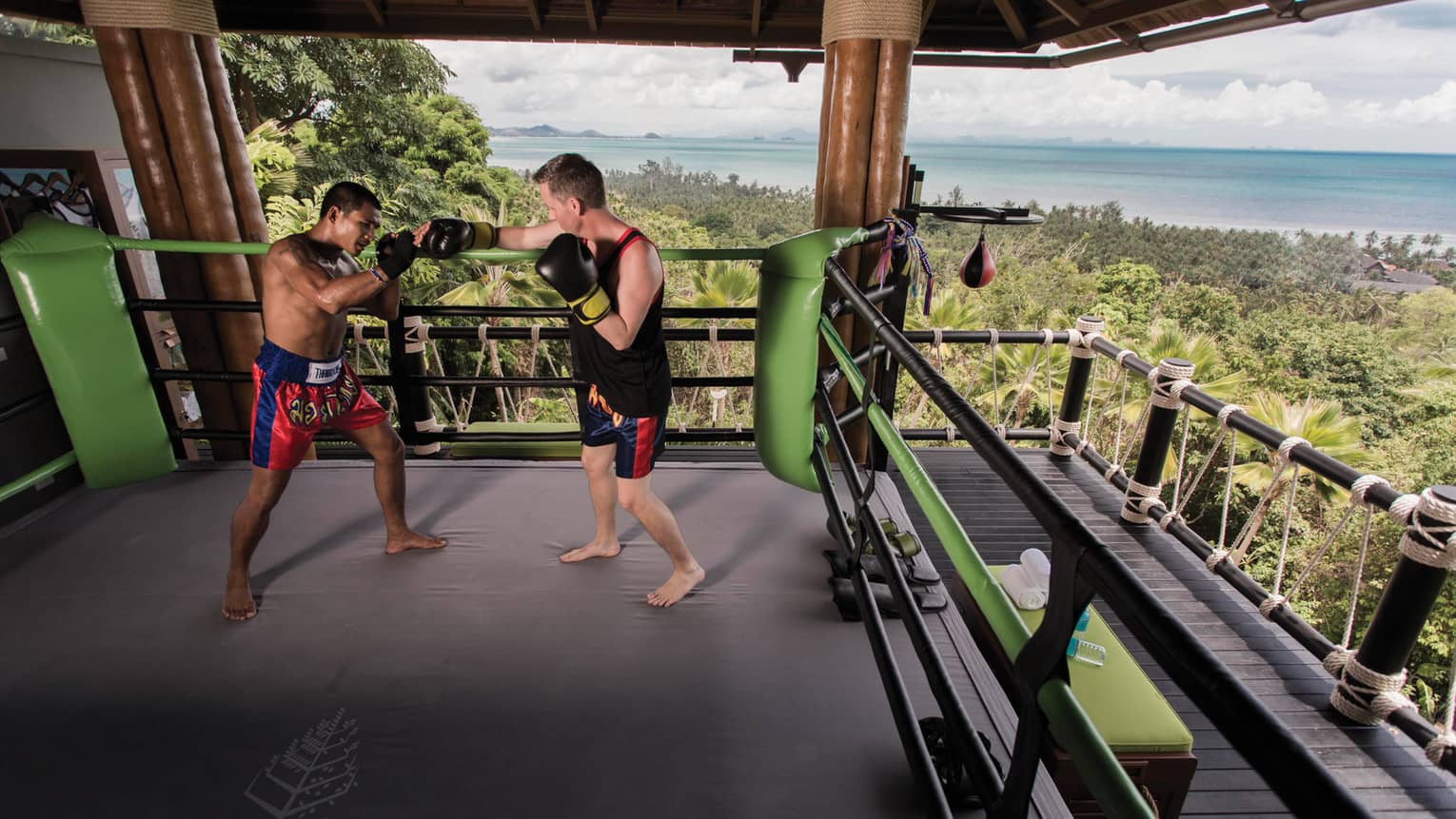 Two boxers practice in Muay Thai boxing ring high up in mountain