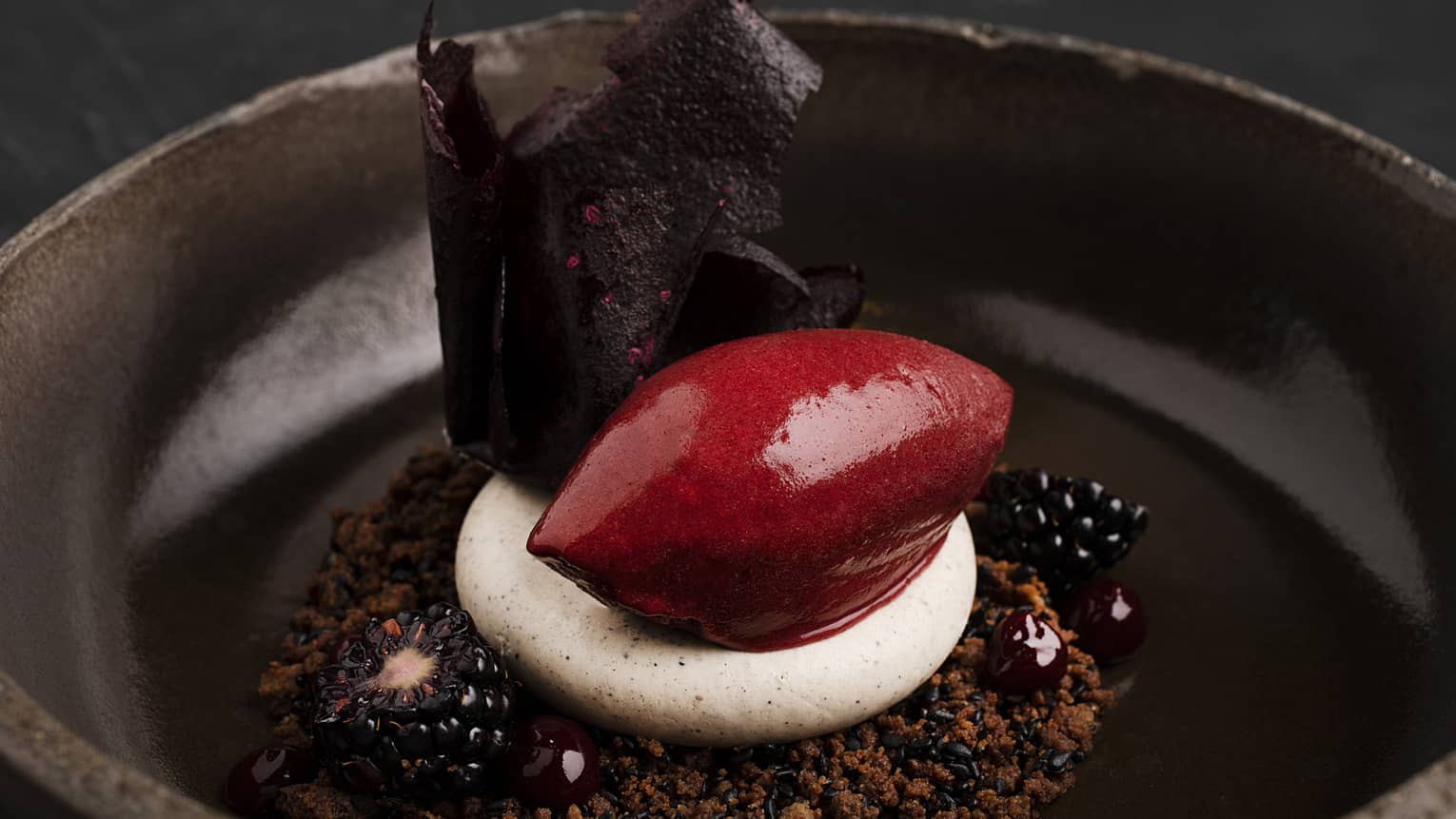Black sesame and chocolate crumble, black sesame mousse, and blackberry-and-lemongrass sorbet served in a dark-brown bowl