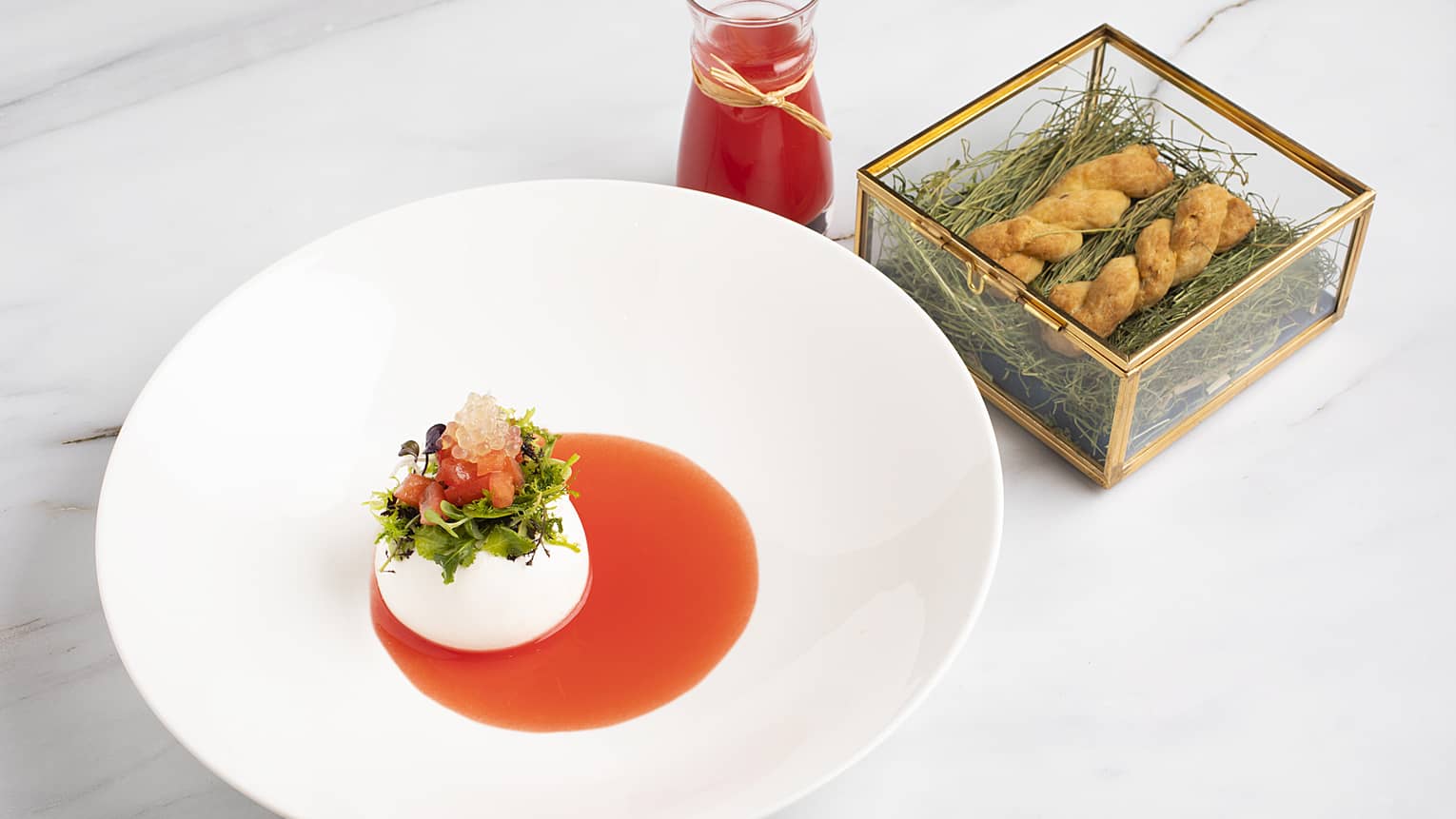 A white porcelain dish with red sauce and cream in the bottom.