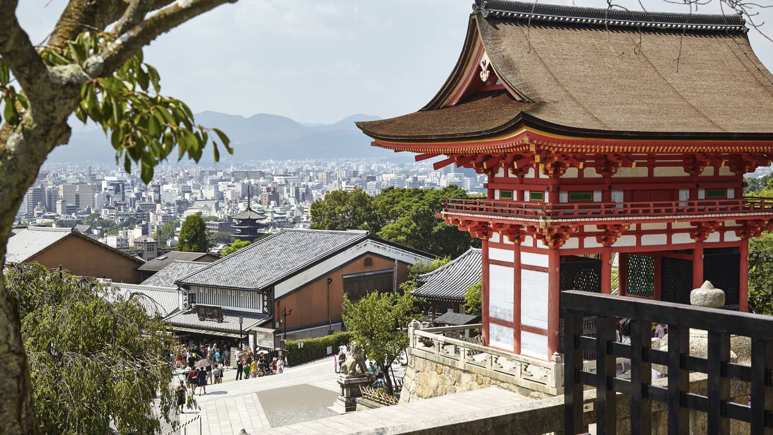 People walk along street under traditional Japanese building, Kyoto city views