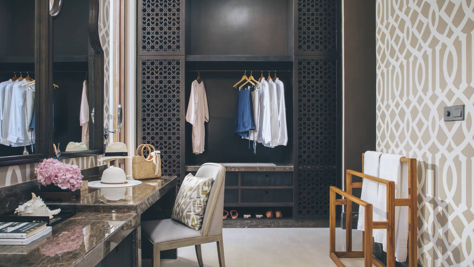 Changing area with closet, make-up vanity and a geometric accent wall