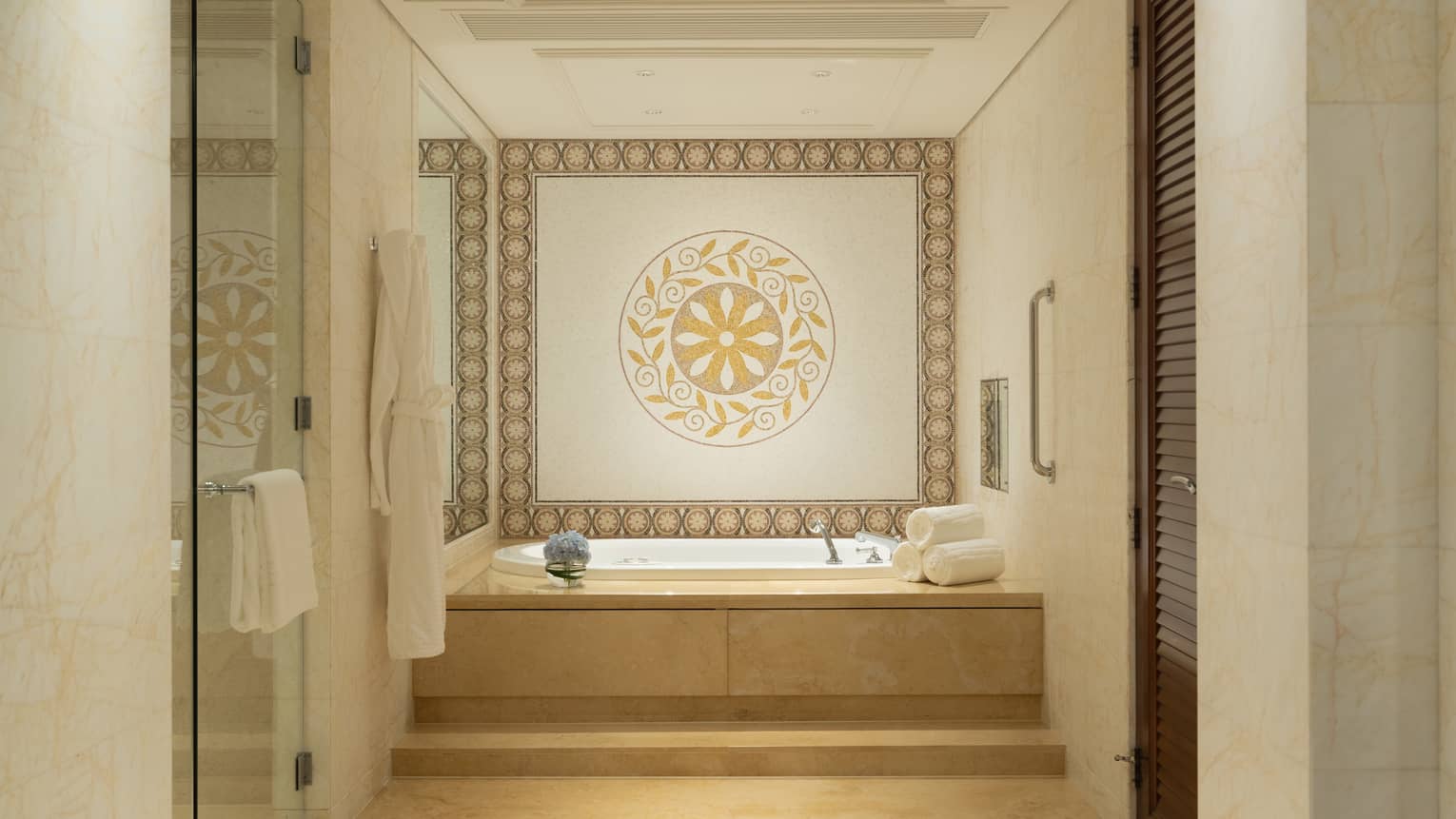 Elegant bathroom with step up to a jetted tub. A tiled accent wall features a circular design.
