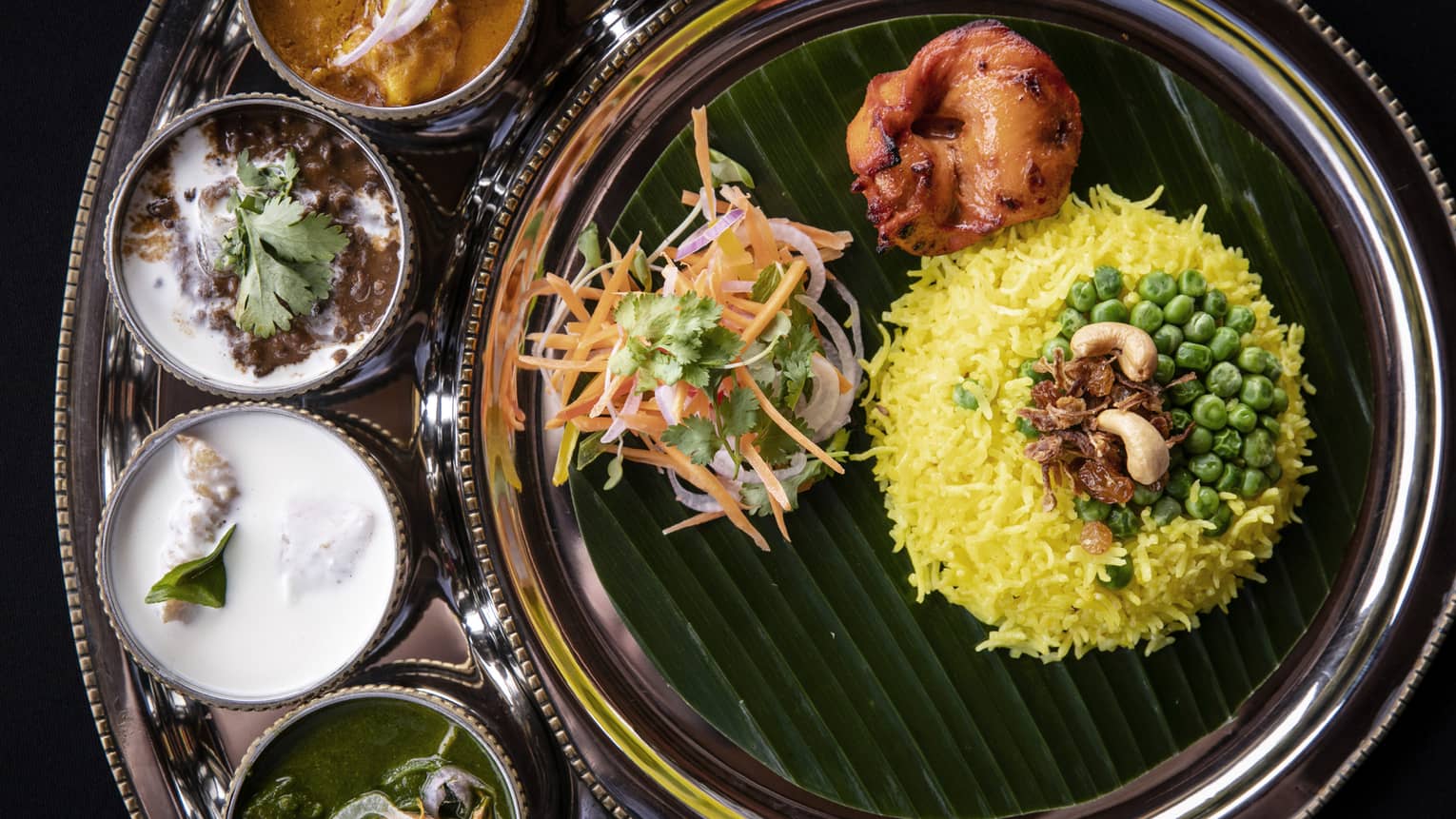 Indian food including rice, four sauces and vegetables.