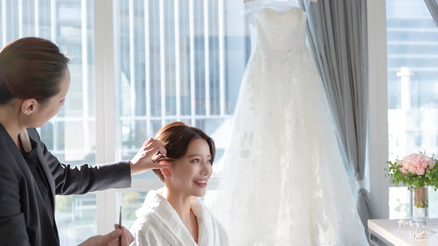 Woman gets hair done for wedding in luxury hotel room