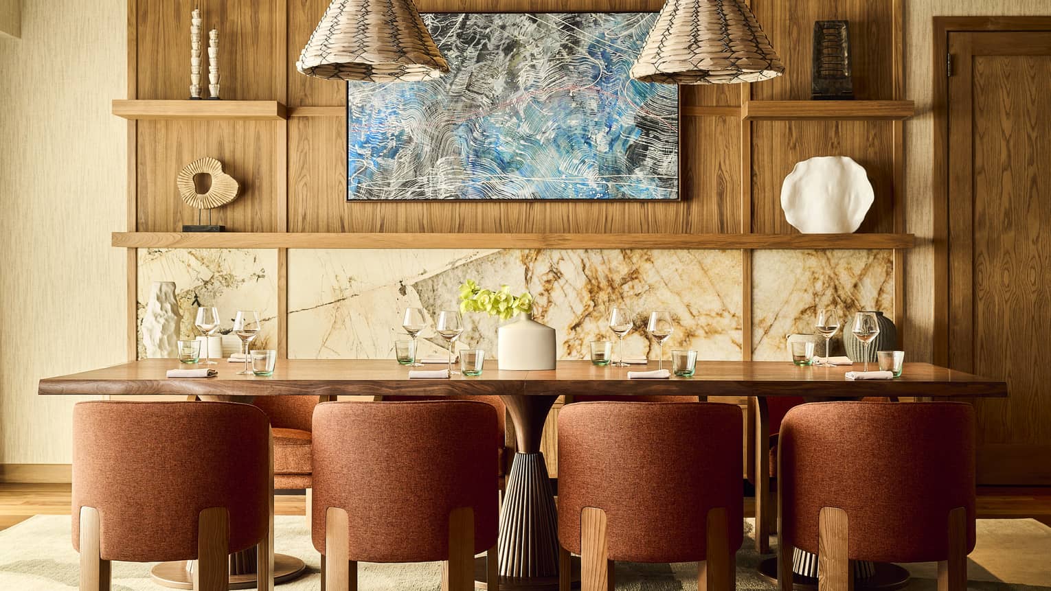 Stylish dining room with eight mauve-coloured chairs and two hanging rattan lights