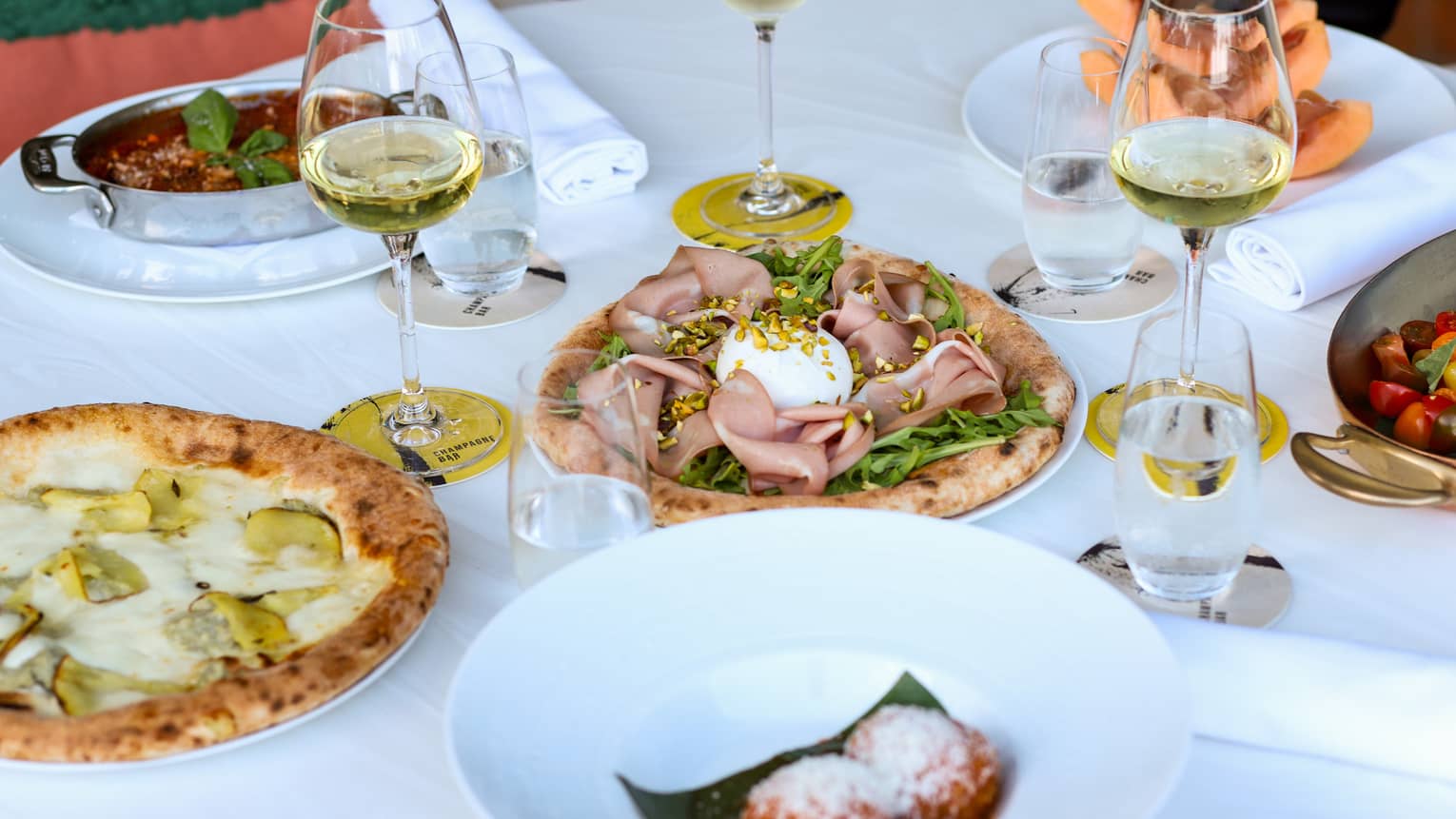 An assortment of pizza with various toppings on a large round table.