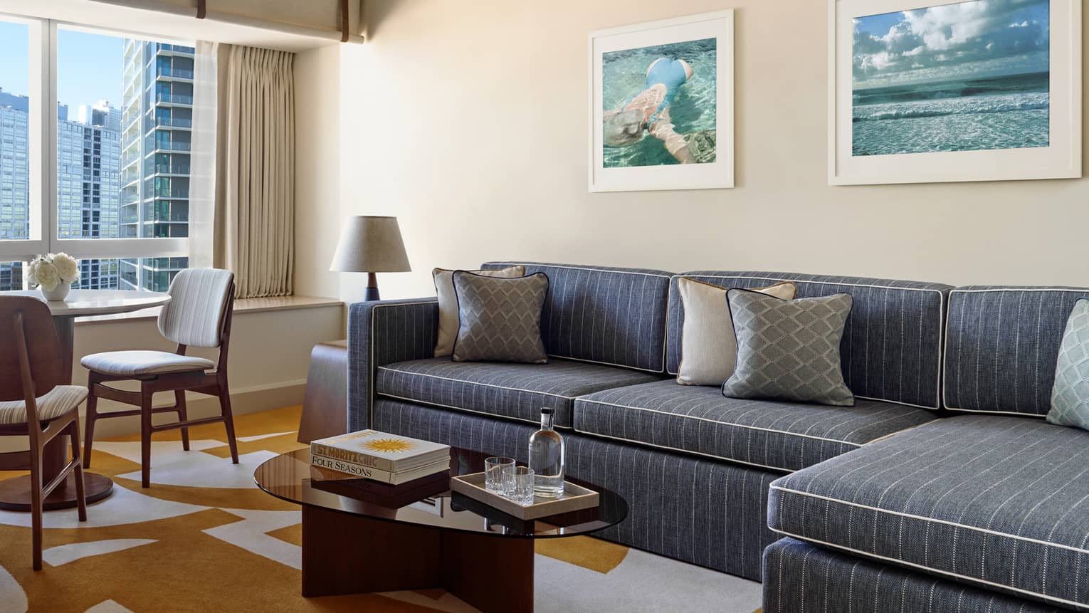 Living room with denim pinstripe sofa, coffee table and table with two chairs