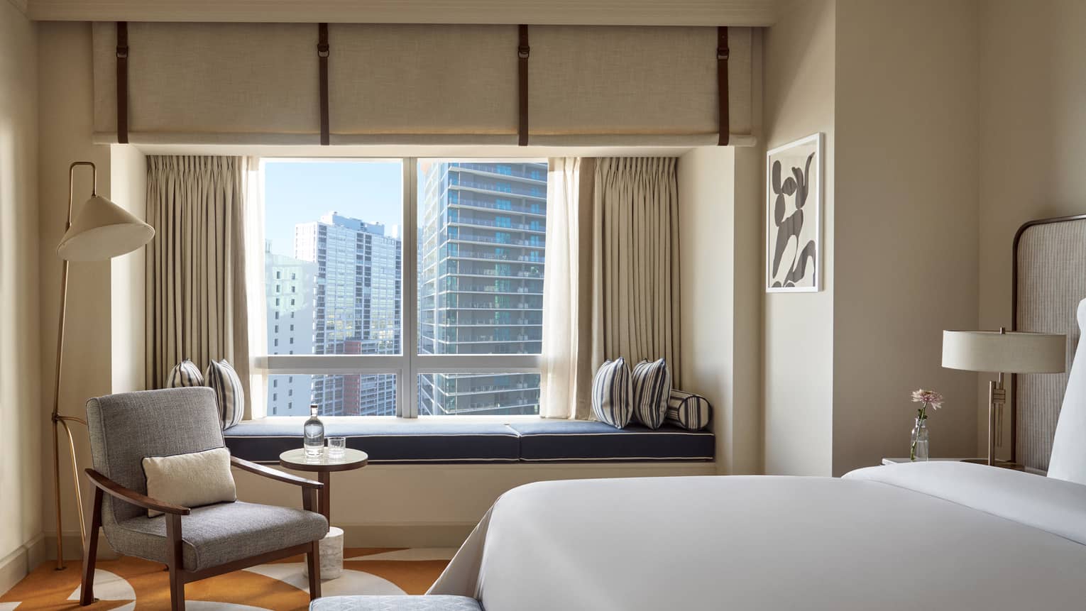 Hotel room with a king bed, arm chair and built-in window bench
