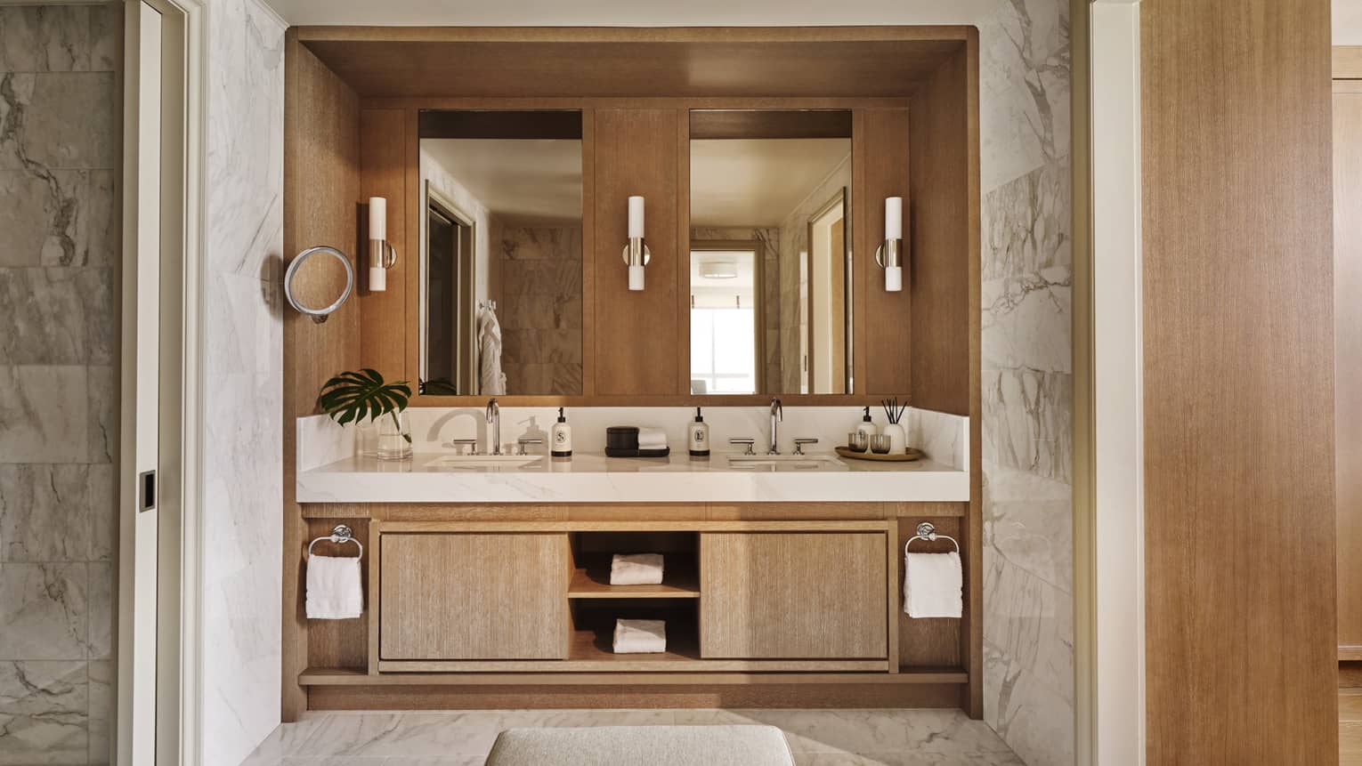 Hotel suite bathroom with double vanity and marble floors and walls