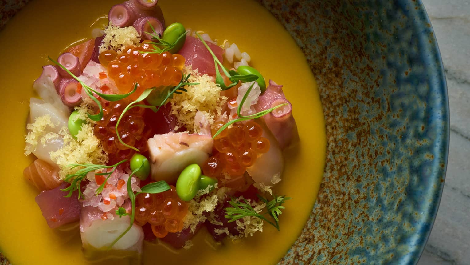 Chirashi poke dish in a blue and red bowl
