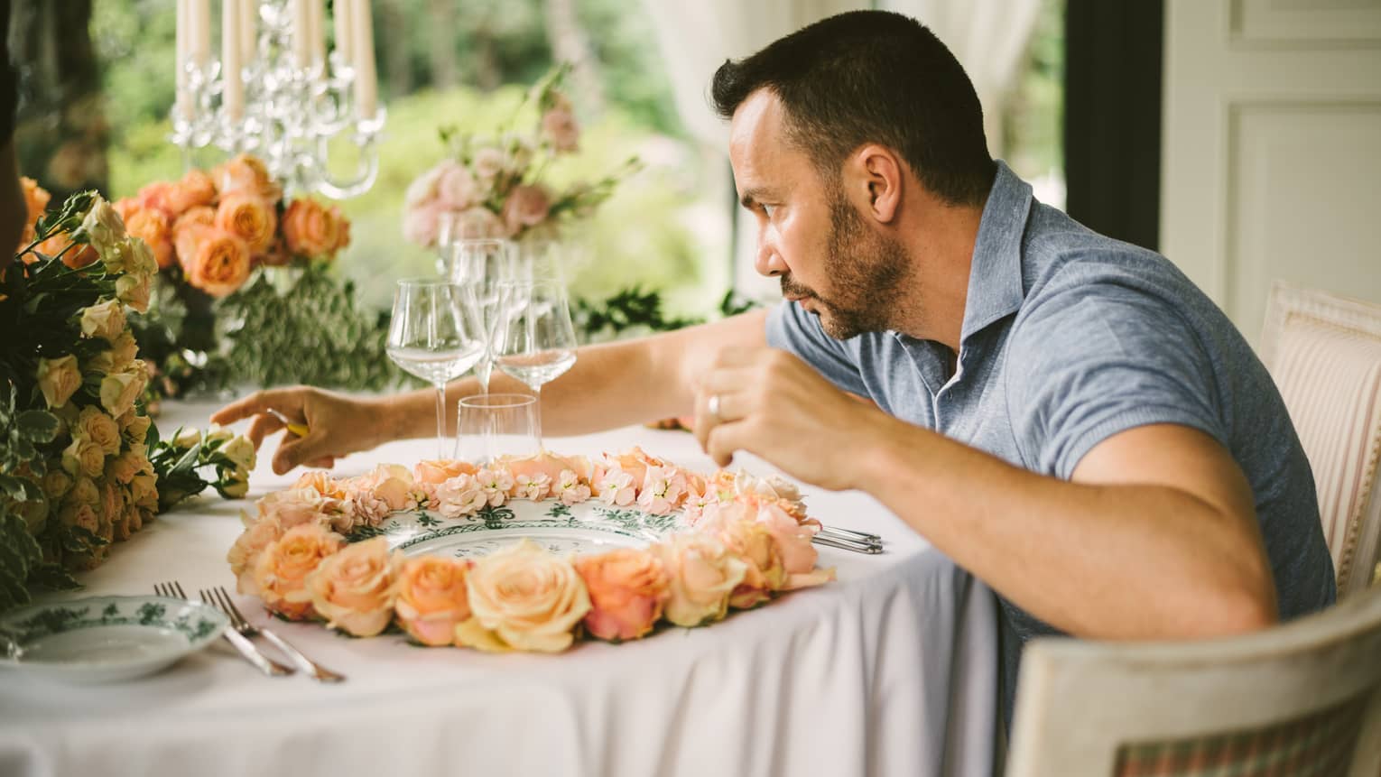 Artistic Director Vincenzo Dascanio carefully arranges roses on wedding dining table