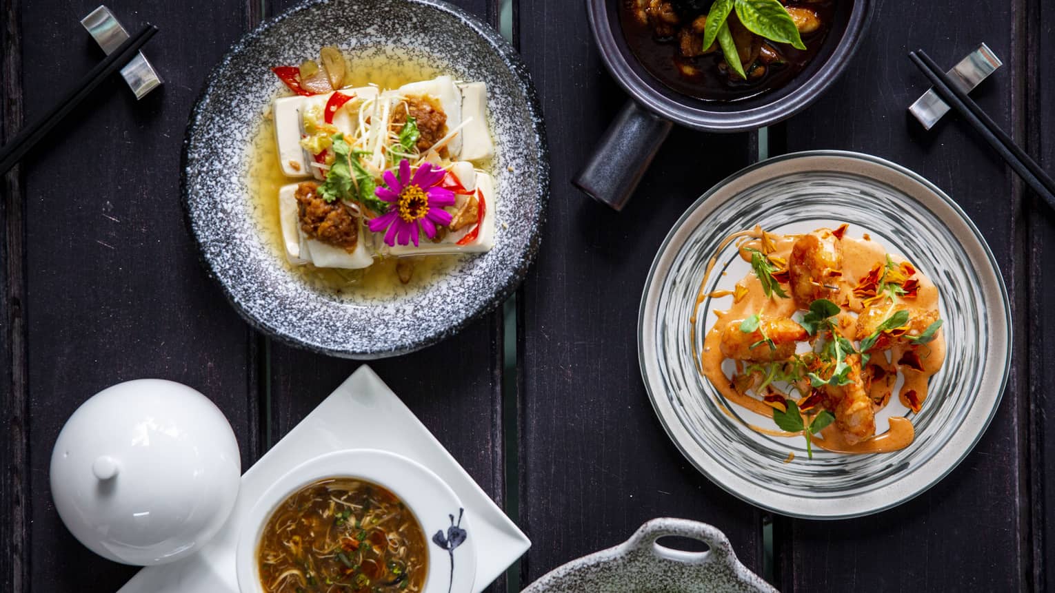 Five colourful dishes made of veggies and flowers on a dark wooden table at Cafe' Landaa
