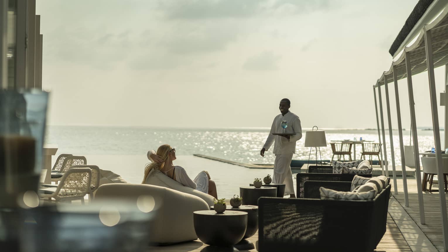 A guest receives a cocktail while relaxing outside at the Blu Beach Club