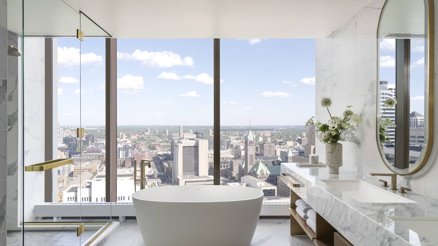 Marble bathroom with free-standing tub and wall of windows
