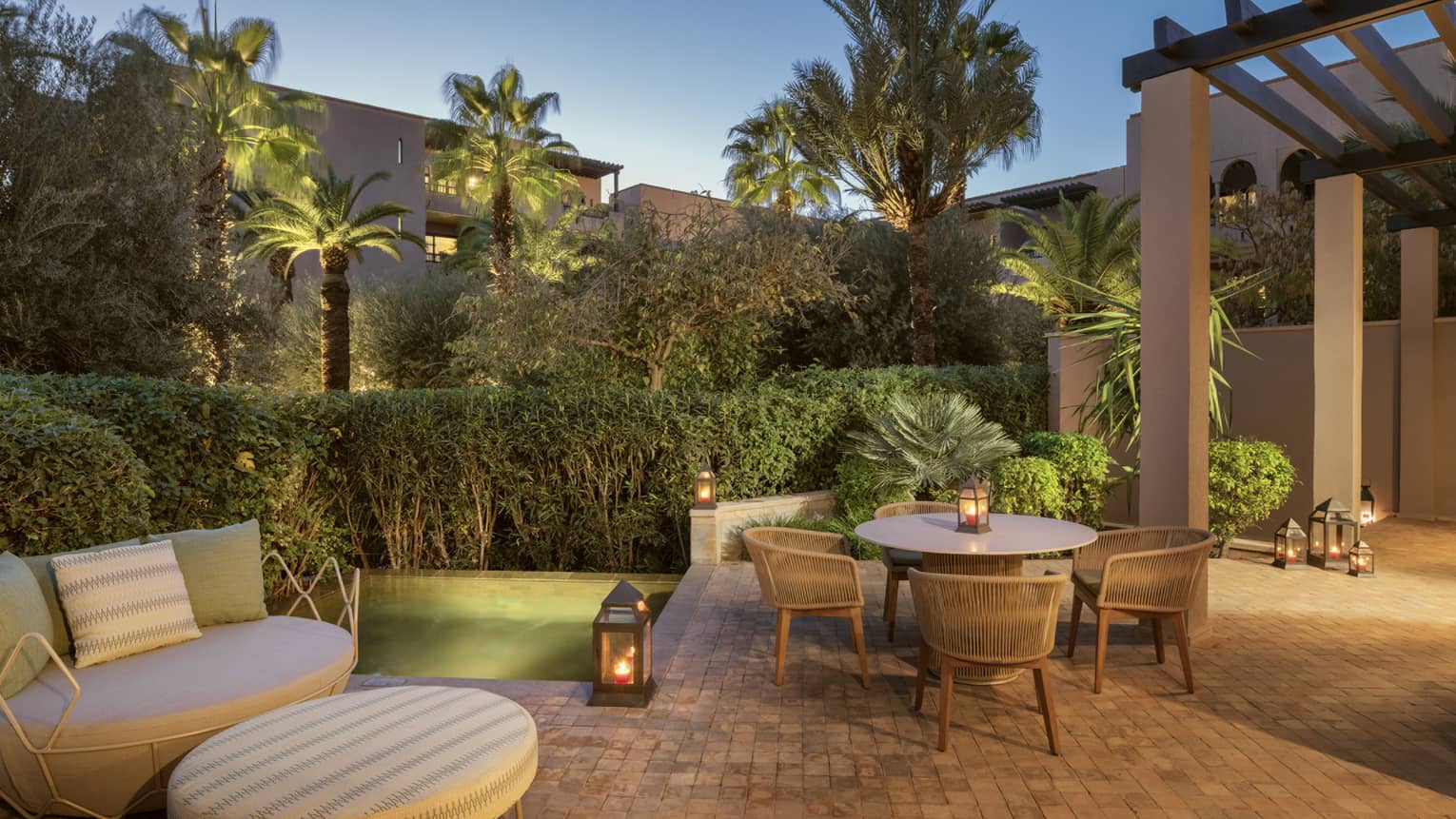 Hotel terrace at dusk, with daybed and dining table