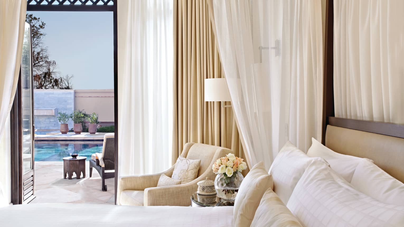 Four-Bedroom Royal Villa with Private Pool, bed with white curtains and armchair beside open balcony door to patio