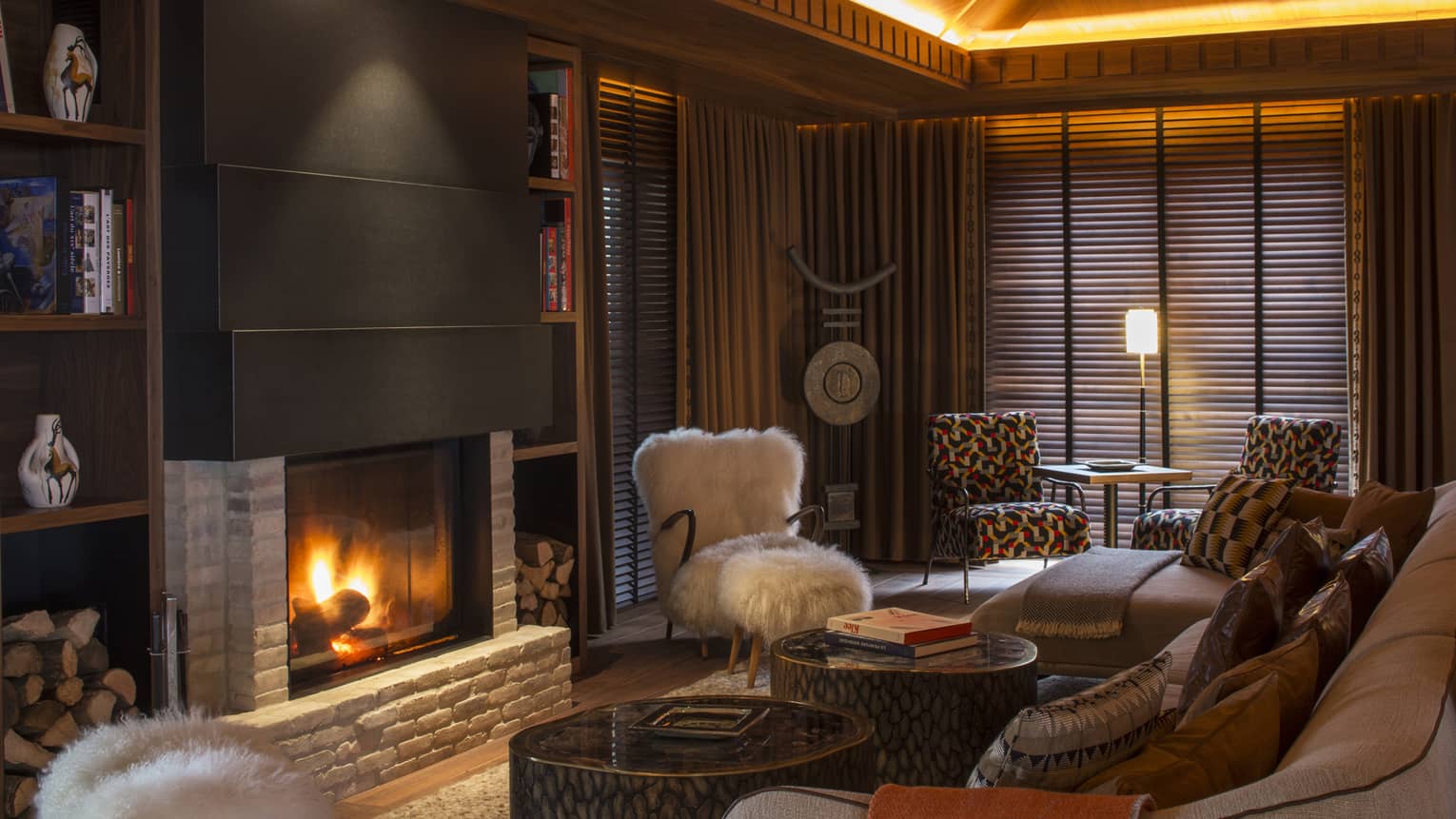 Large fireplace with stone and wood detail in cosy Lobby Lounge with brown tones 