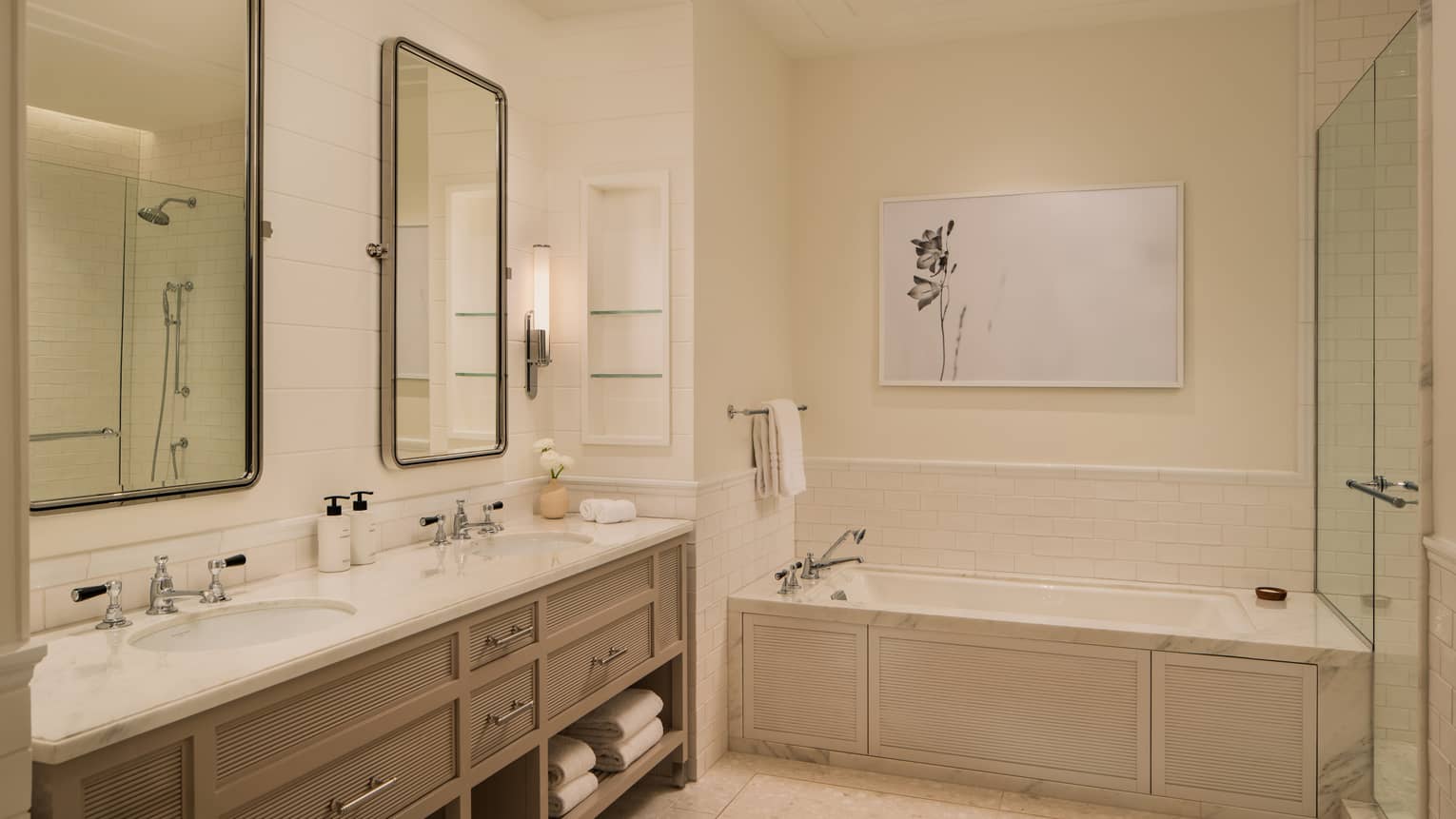 Hotel bathroom with a double vanity, sunken tub and glass shower