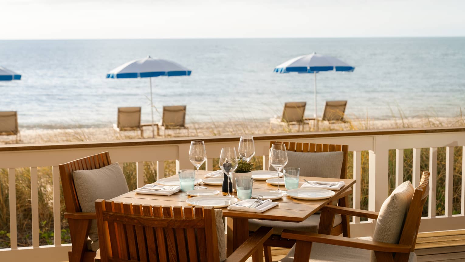 Table for four set on an outdoor terrace overlooking the beach