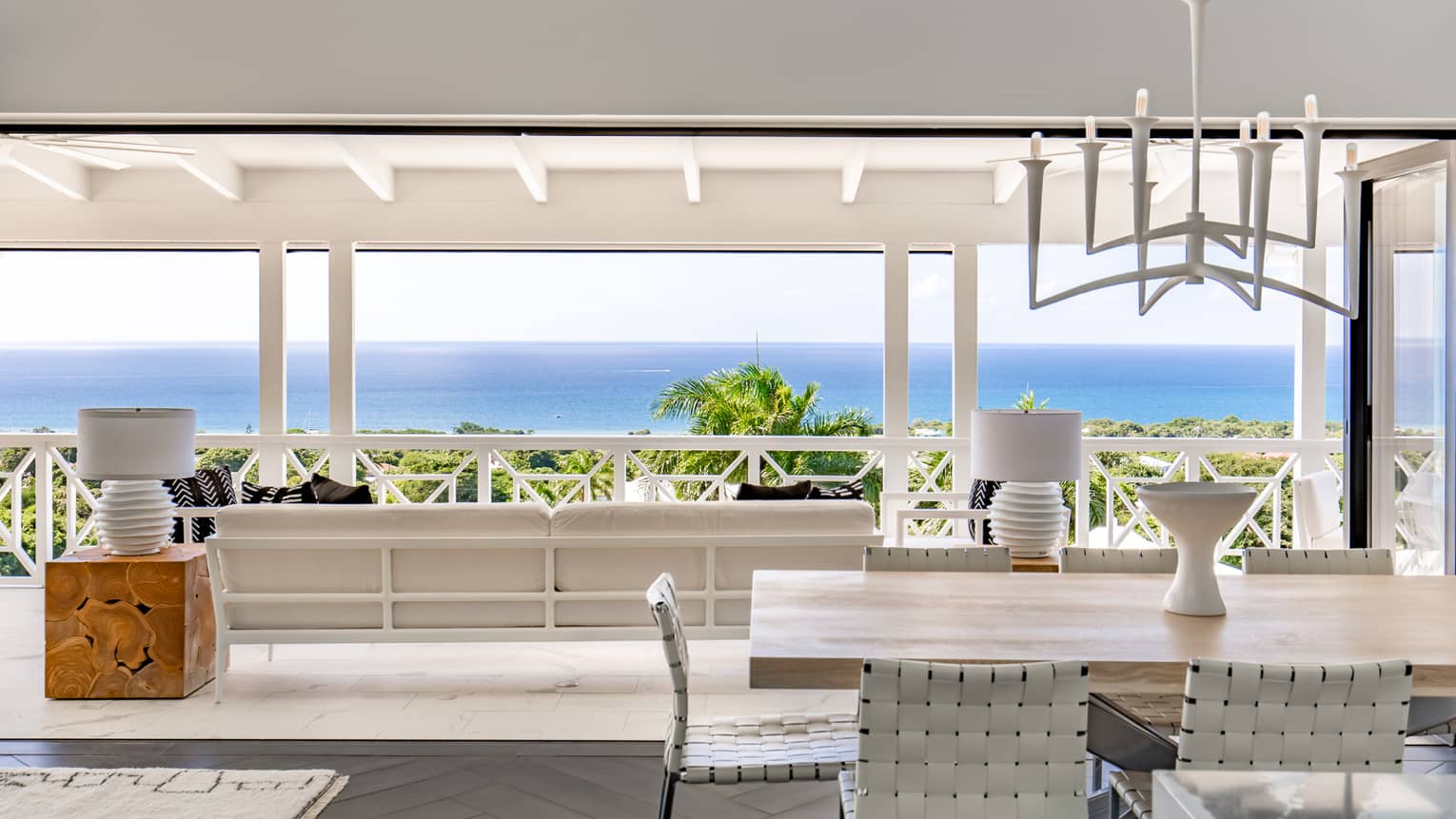 Interior of residence living room, terrace and ocean beyond