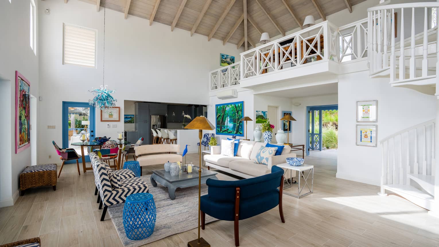 Tropical villa's living room with high vaulted ceiling and mismatched sofas