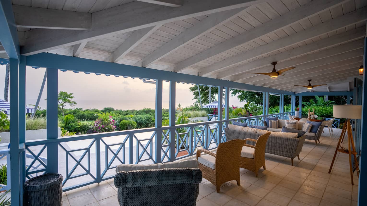 A tropical villa's covered terrace overlooking pool and ocean