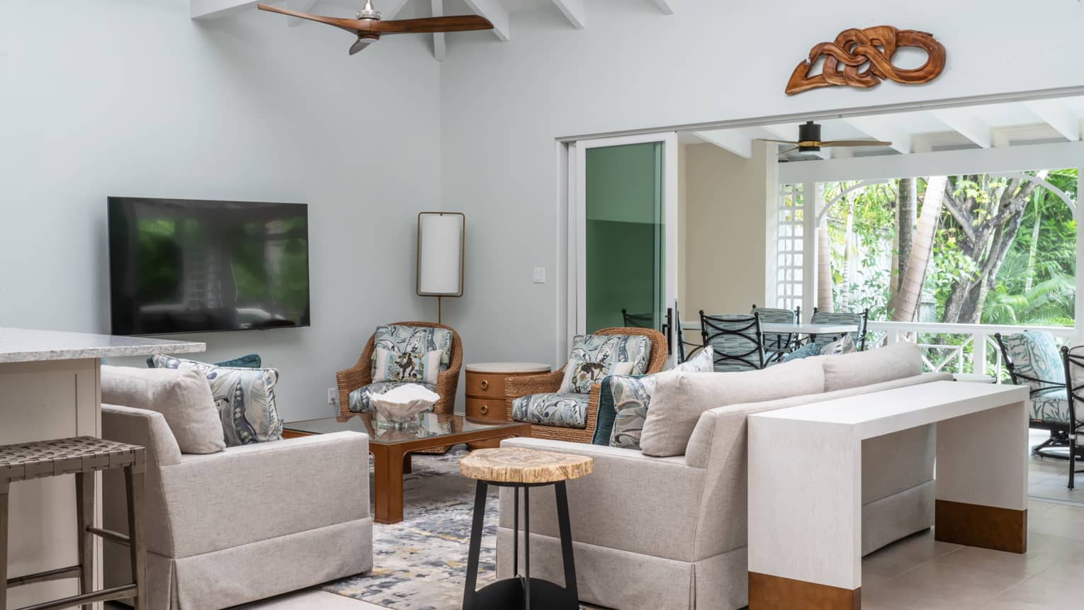Living room of private residence in tropical setting, with white, vaulted, wooden beam ceiling