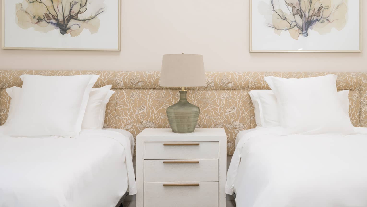 Bedroom with two single beds and floral artwork