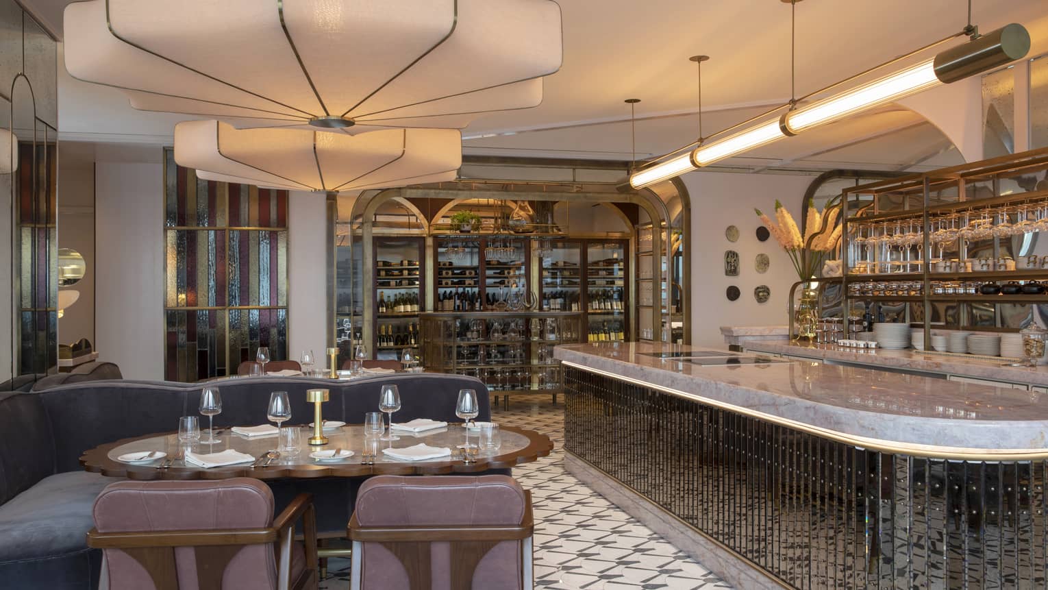 Miss River dining area with viewing kitchen, tube lighting, round tables, faded blue booths