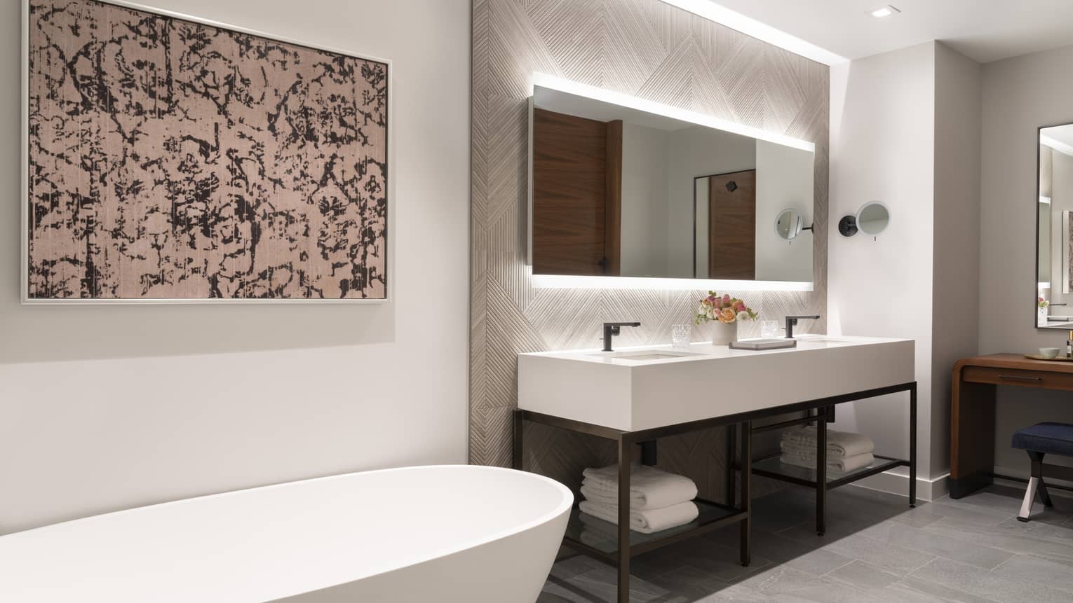 Modern bathroom with illuminated double vanity and standalone tub
