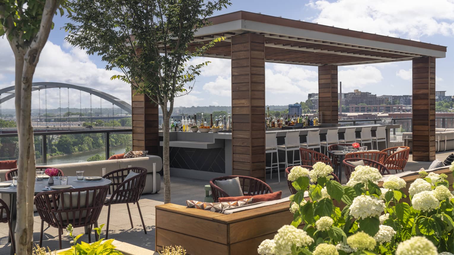 Rooftop terrace with a bar area and view of the city.
